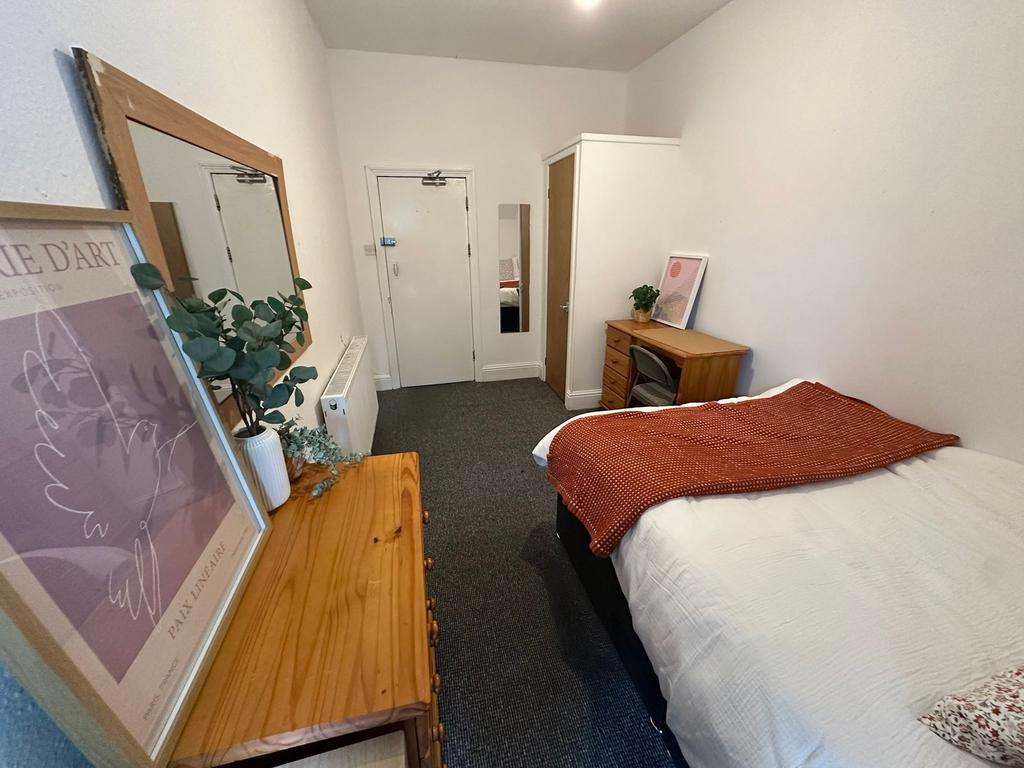 A cozy double bedroom featuring a comfortable b...