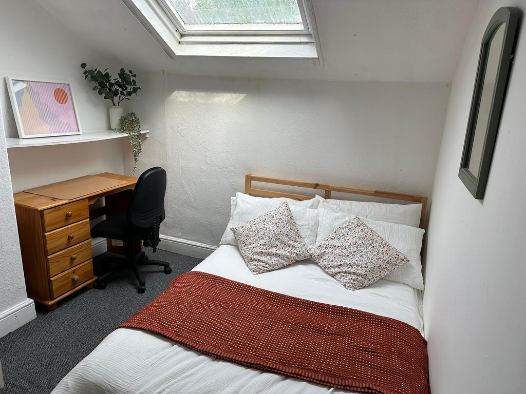 Cozy and well-lit bedroom featuring a comfortab...