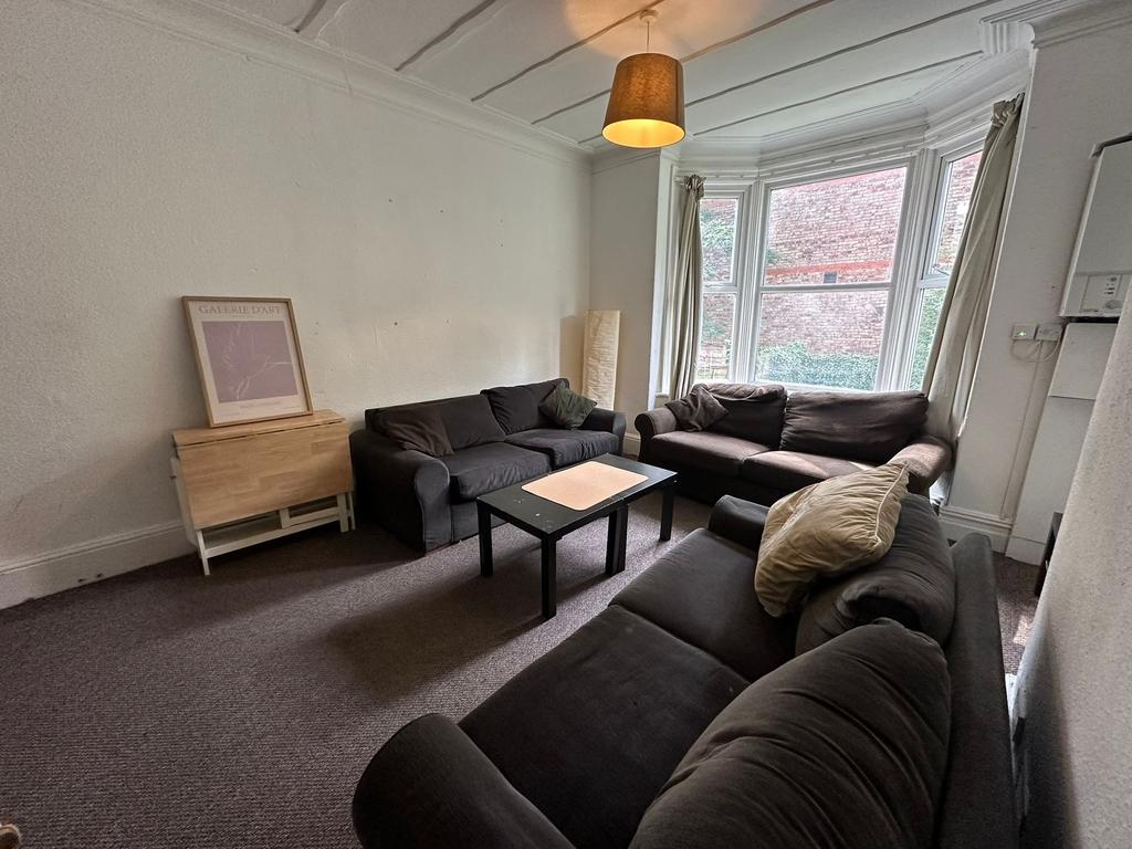 A spacious, well-lit living room featuring a la...