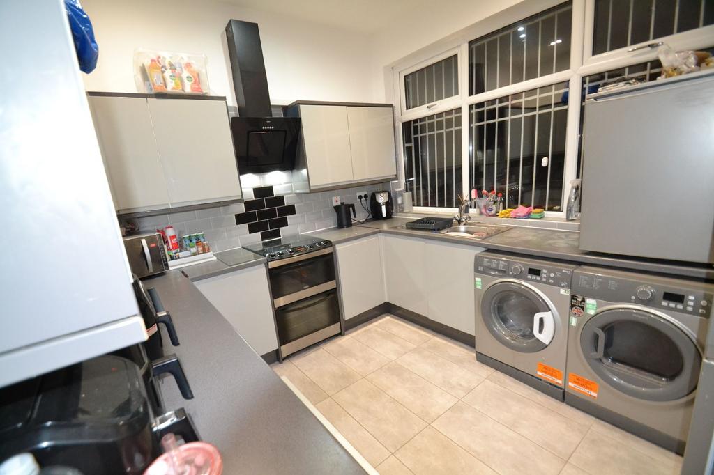 Modern galley-style kitchen with grey cabinets,...
