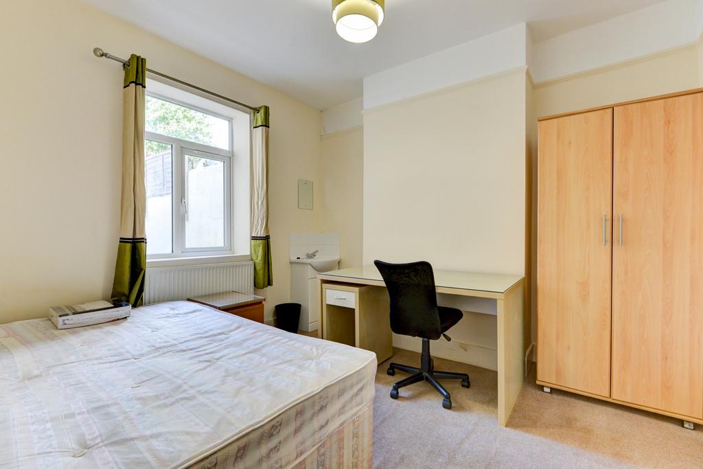 A bright and tidy bedroom featuring a comfortab...