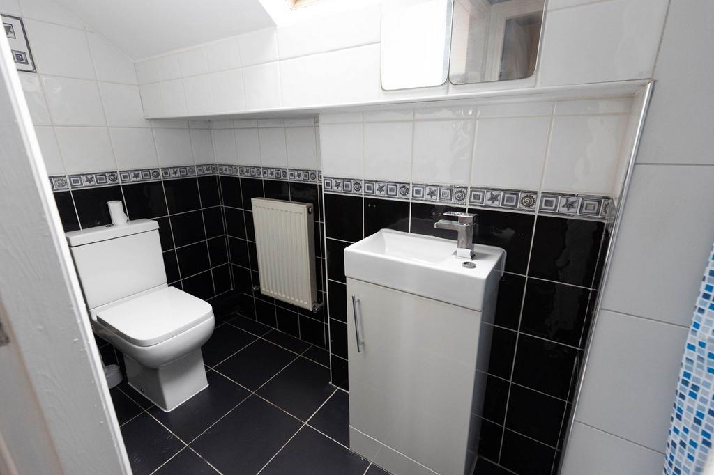 Modern bathroom with a toilet and a small sink,...