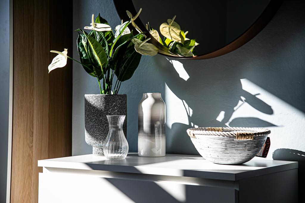 Bright, stylish entrance vignette with sculptur...
