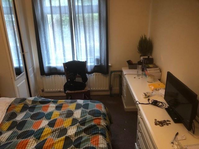 Bright bedroom with a patterned double bed, lar...
