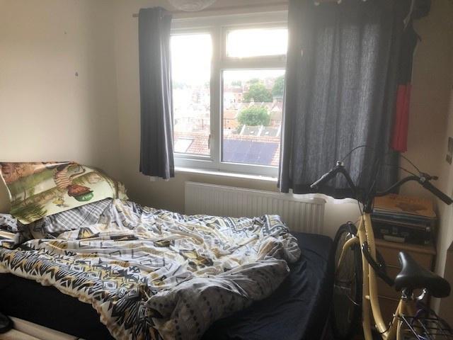 Cozy bedroom with a large window offering stree...