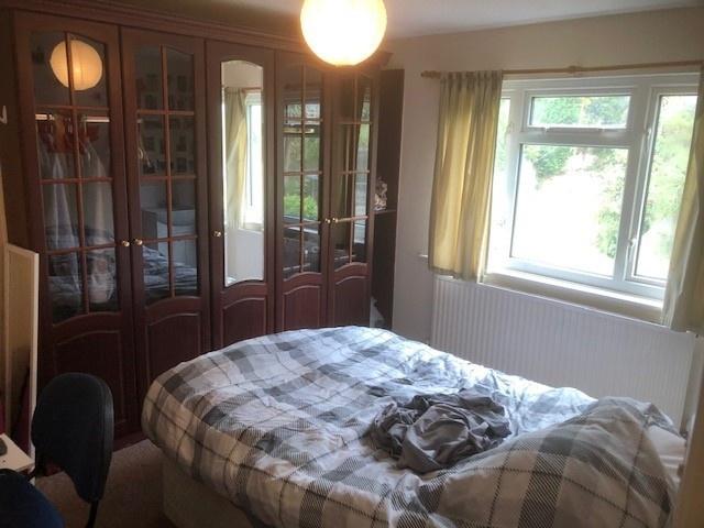 Bright double bedroom with a large window, buil...