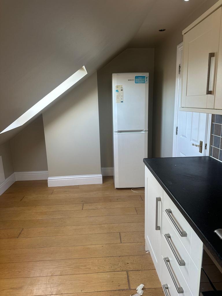 Bright kitchen corner with sloped ceiling and s...