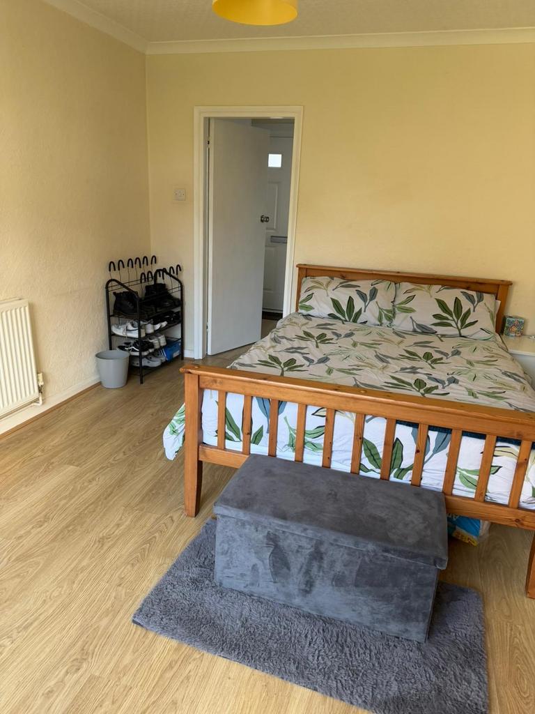 Bright double bedroom with a wooden bedframe, l...