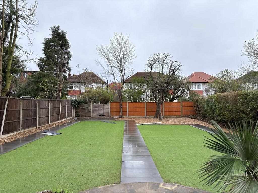 Well-kept rear garden with a central paved path...