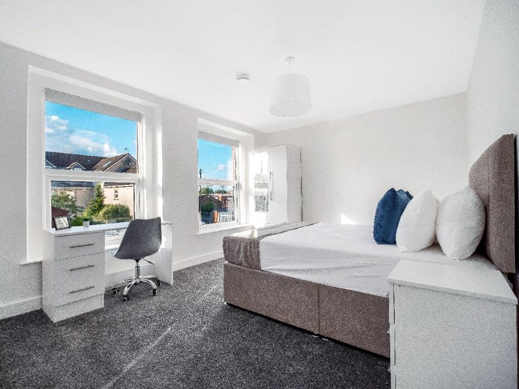 Bright, modern double bedroom with large sash w...