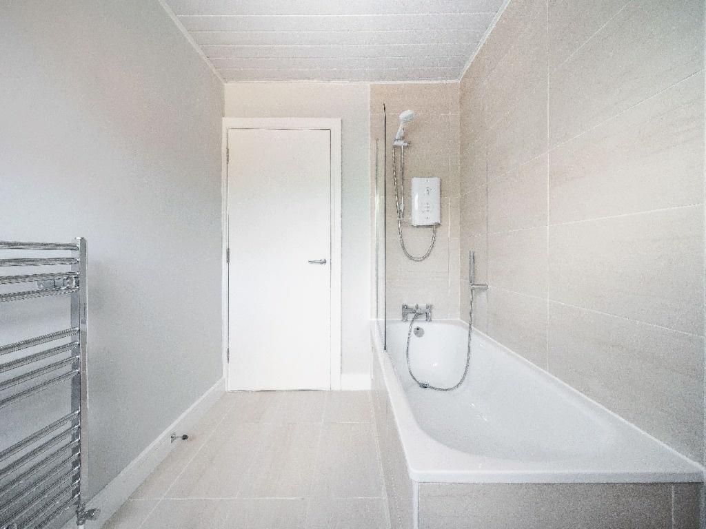 Bright, modern bathroom with a full-size bathtu...
