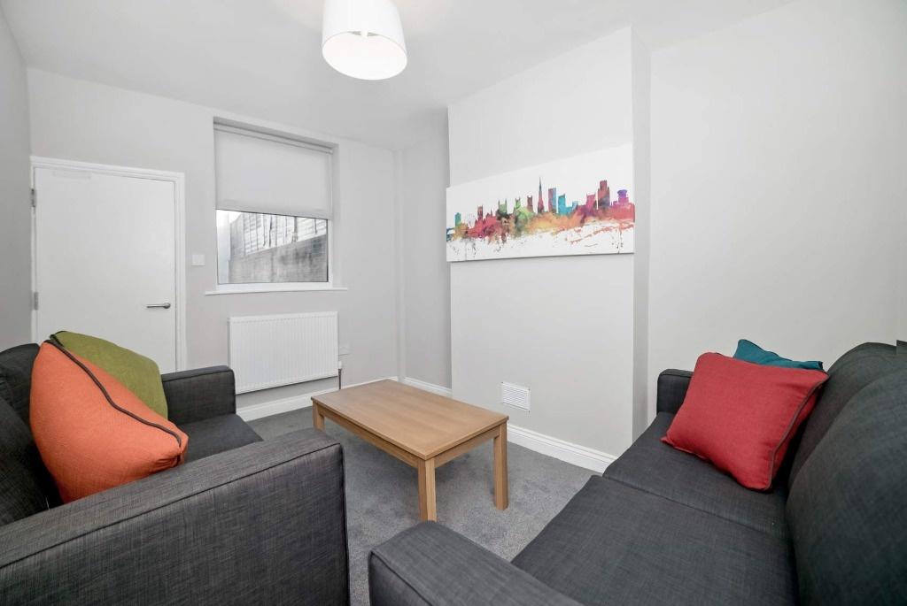 Bright, modern lounge with two grey sofas facin...