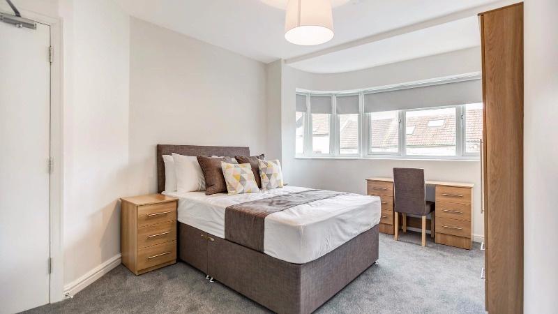 Bright, neatly styled double bedroom with a com...