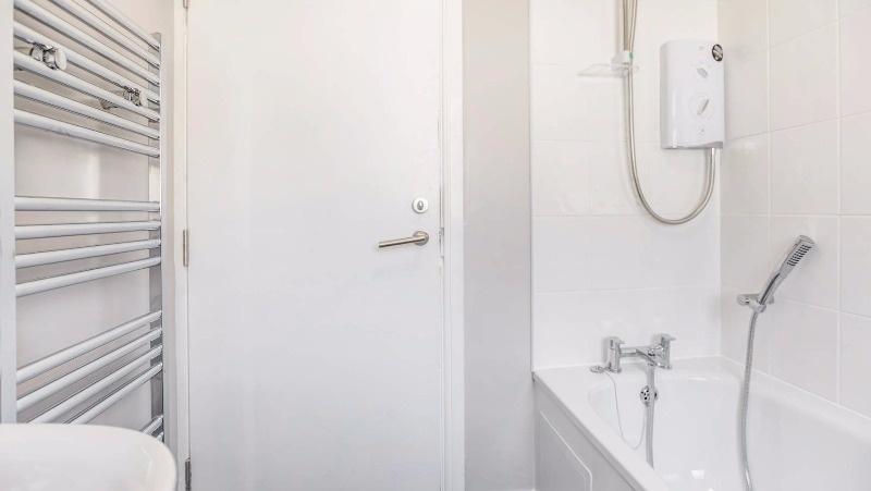 Bright, modern bathroom with clean white tiles,...