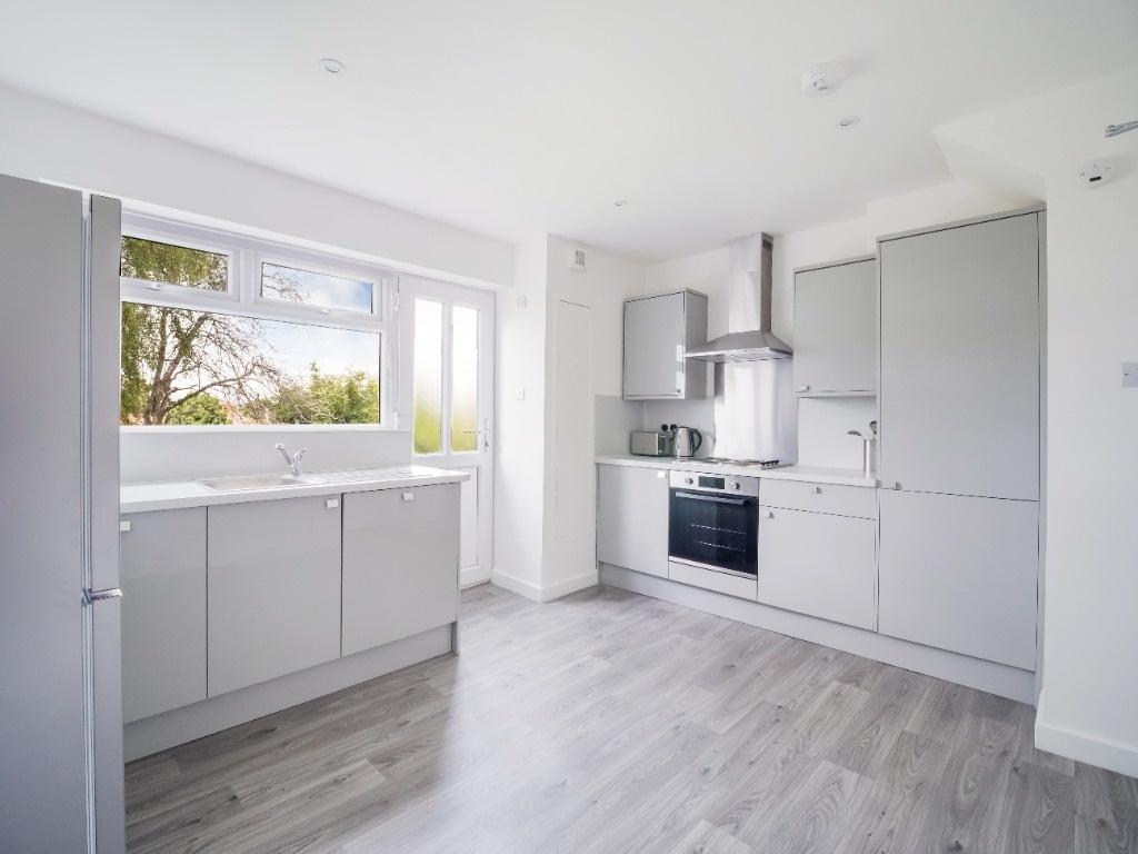 Bright, modern kitchen with sleek grey cabinets...