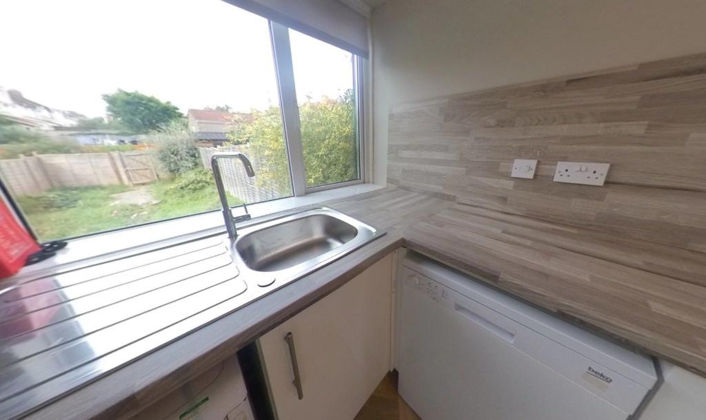 Bright galley-style kitchen with a large window...