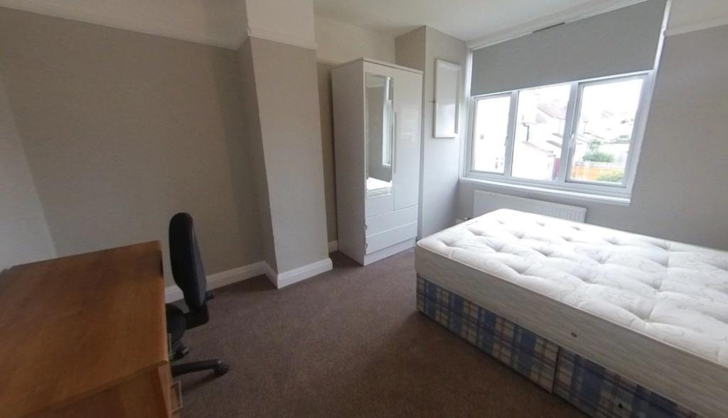Bright, neutral bedroom featuring a comfortable...
