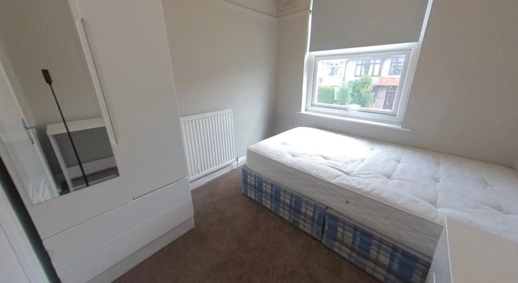 Bright, simply furnished bedroom with a single ...
