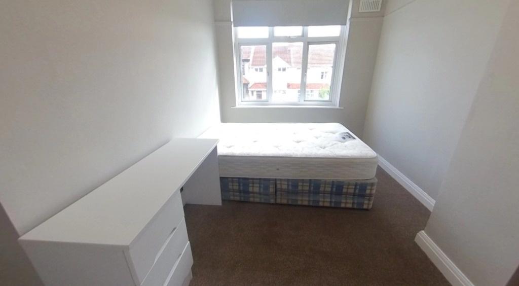 Bright, simply furnished bedroom with a large f...