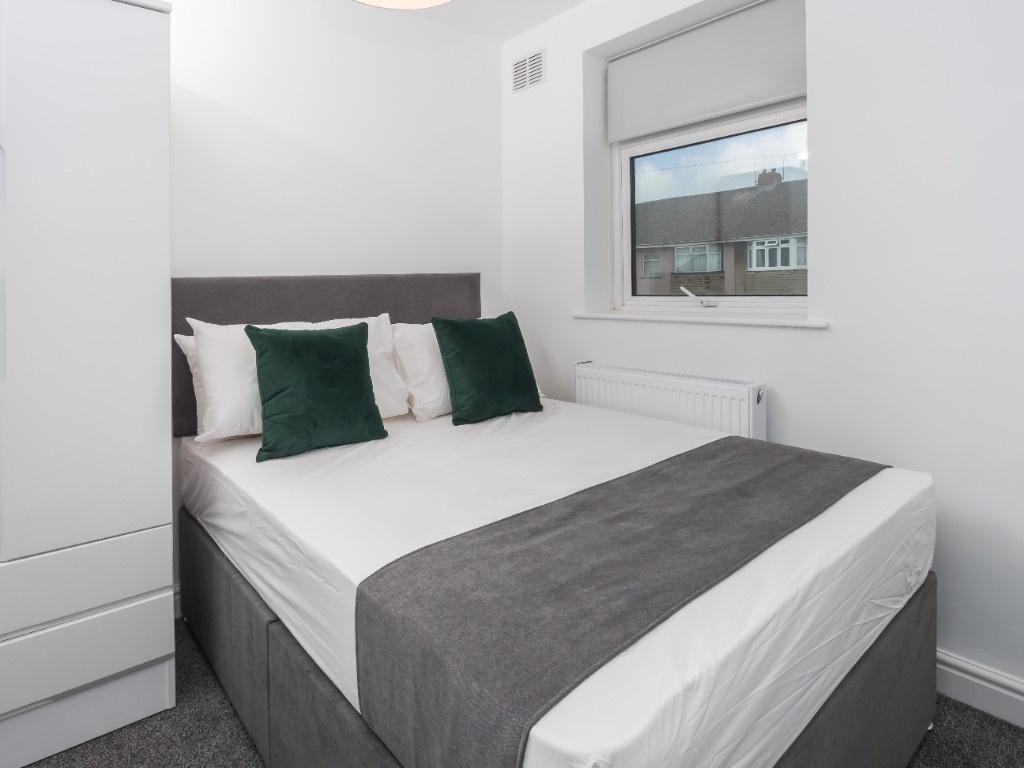 Bright, neatly styled bedroom with a comfortabl...