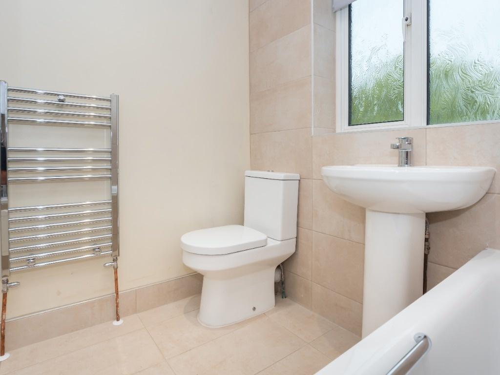Bright, modern bathroom with a pedestal sink, c...