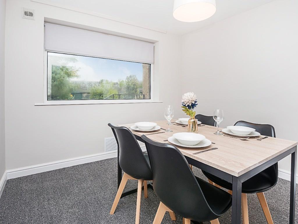 Bright, minimalist dining area with a large win...