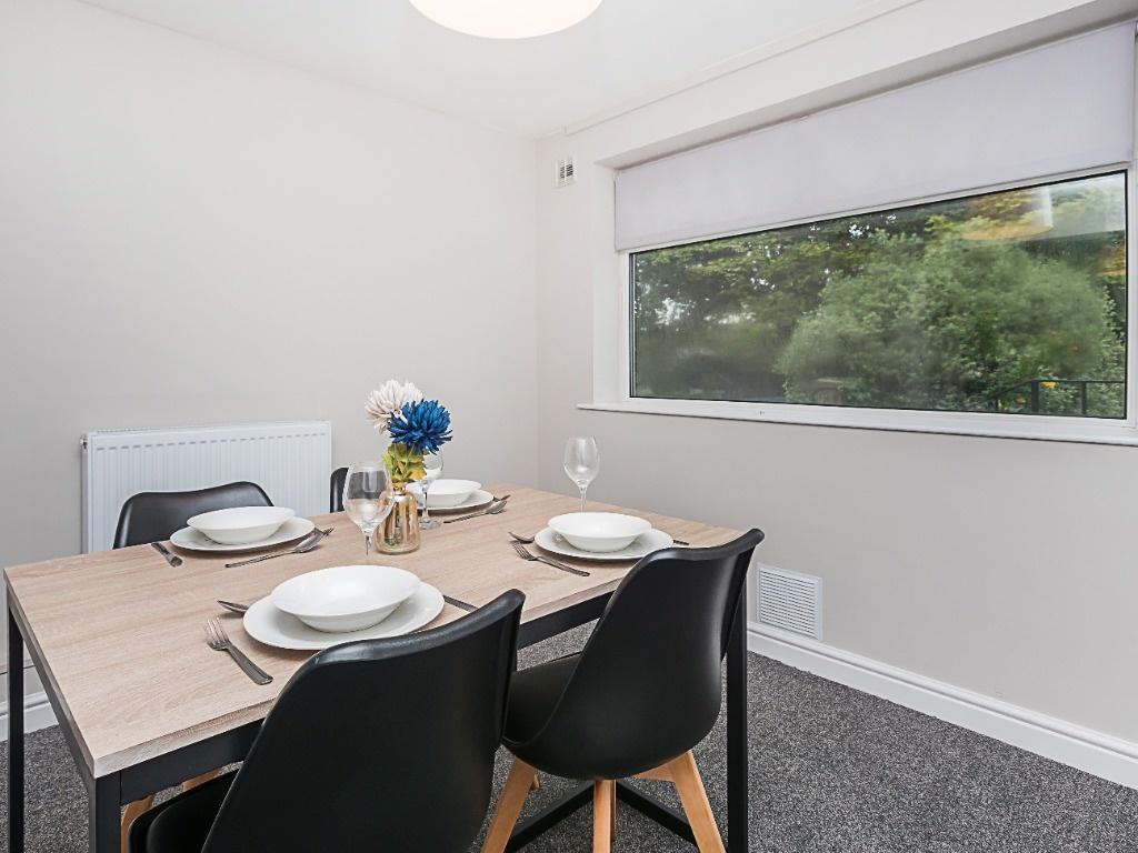 Bright, modern dining area with a light wood ta...