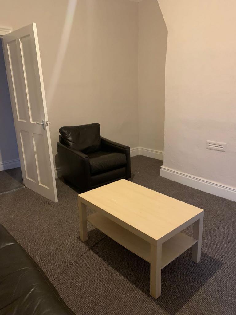 Simple furnished living room with a light wood ...