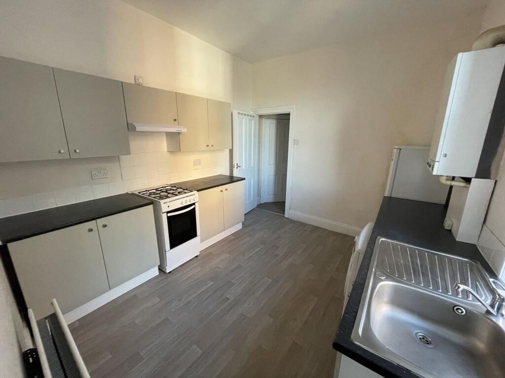 Bright galley-style kitchen with modern laminat...