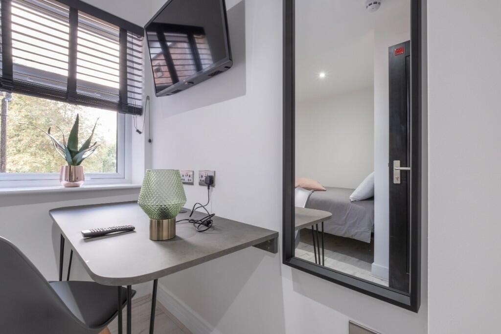 A bright and tidy single bedroom featuring a co...