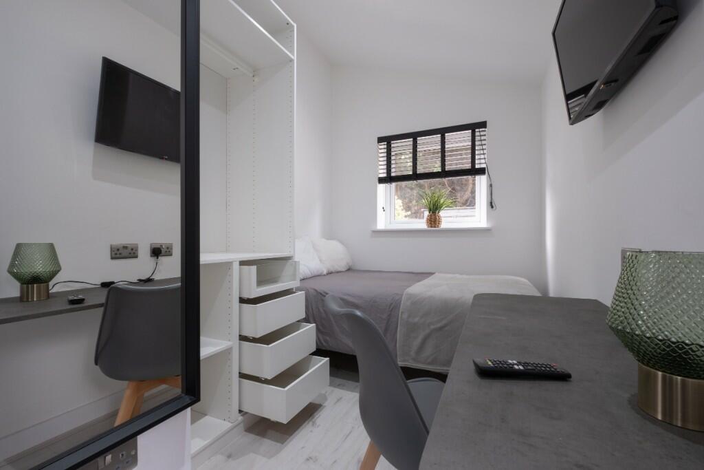 A modern and tidy single bedroom featuring a ne...