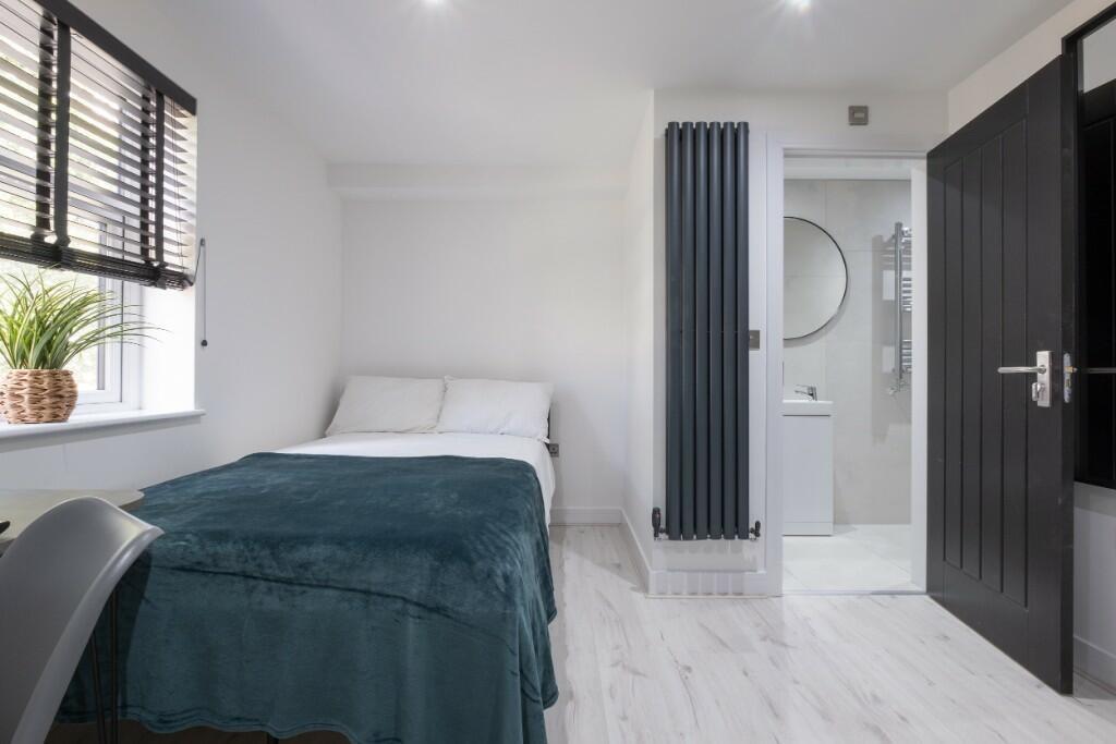 Bright and modern master bedroom featuring a co...