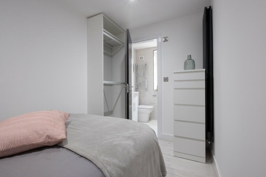 A modern and neatly maintained master bedroom f...