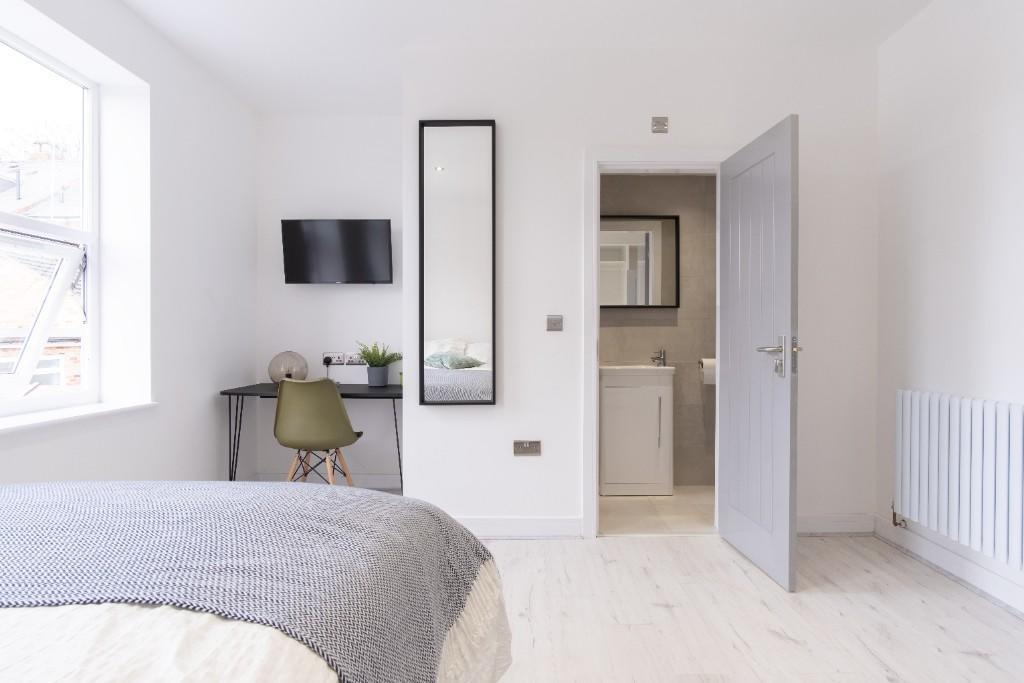 A bright and airy master bedroom featuring a co...