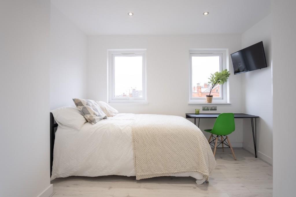 A bright and clean double bedroom featuring a c...
