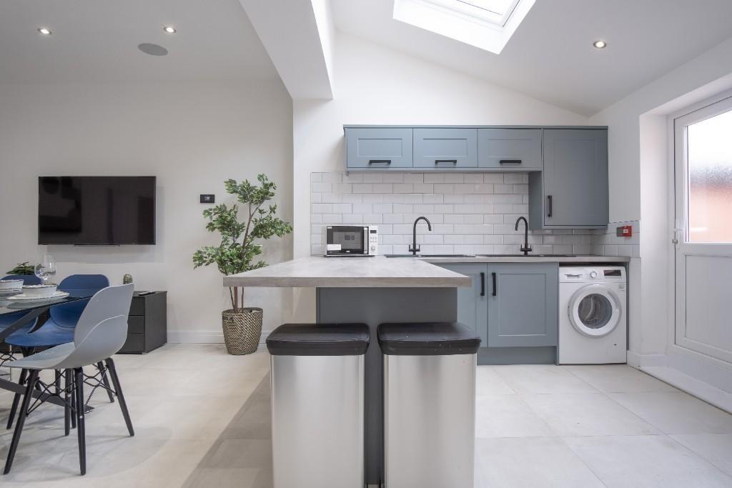 Modern kitchen with sleek grey cabinetry, a bui...