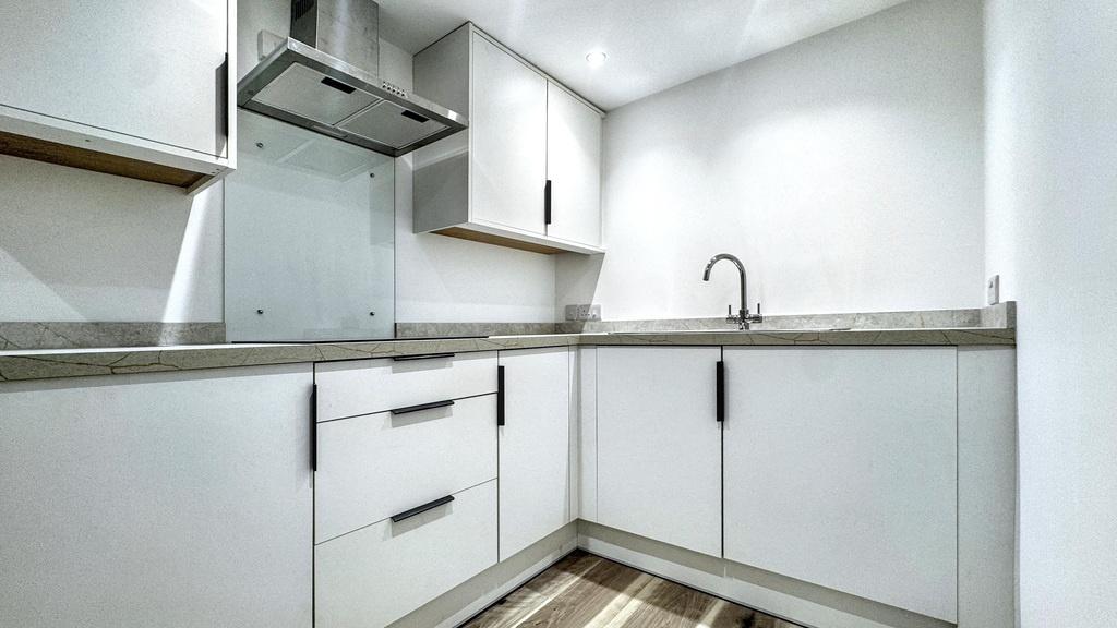 Bright modern kitchen with white handleless uni...