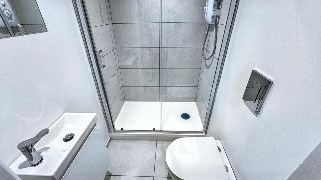 Modern compact bathroom with a tiled walk-in sh...