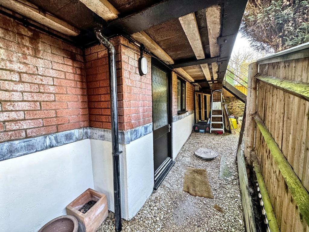A tidy outdoor side passage with pebble ground,...