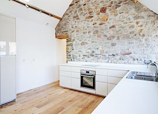 Bright, modern kitchen with sleek white cabinet...