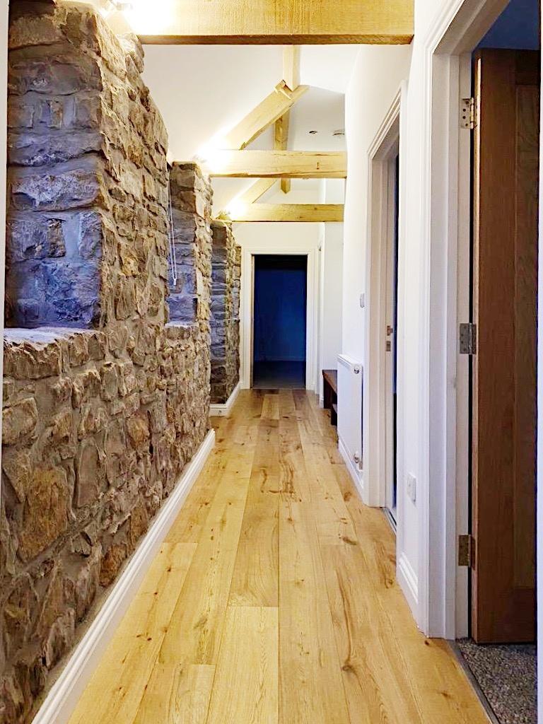 Bright, well-finished hallway with exposed ston...