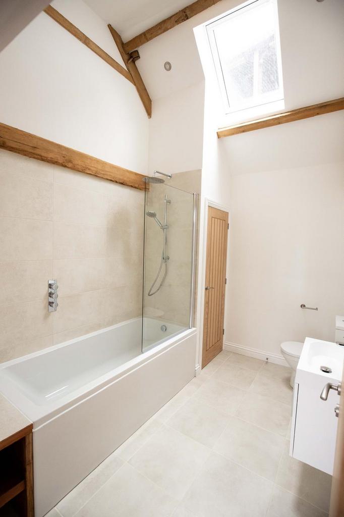 Bright, modern bathroom with a full bathtub and...