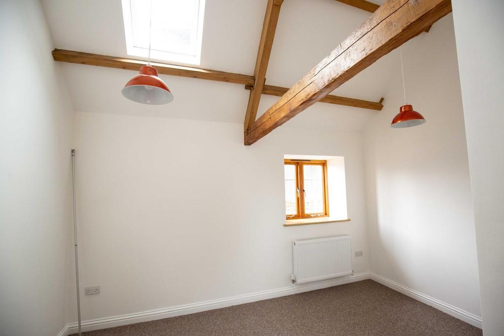 Bright, freshly painted bedroom with exposed ti...