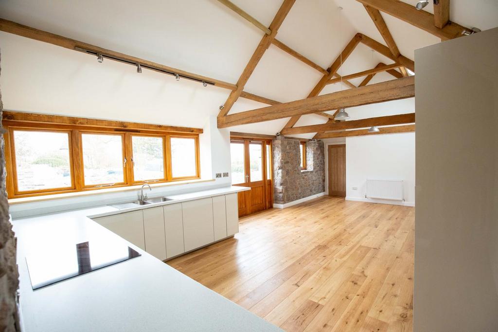 Bright open-plan living space with exposed timb...