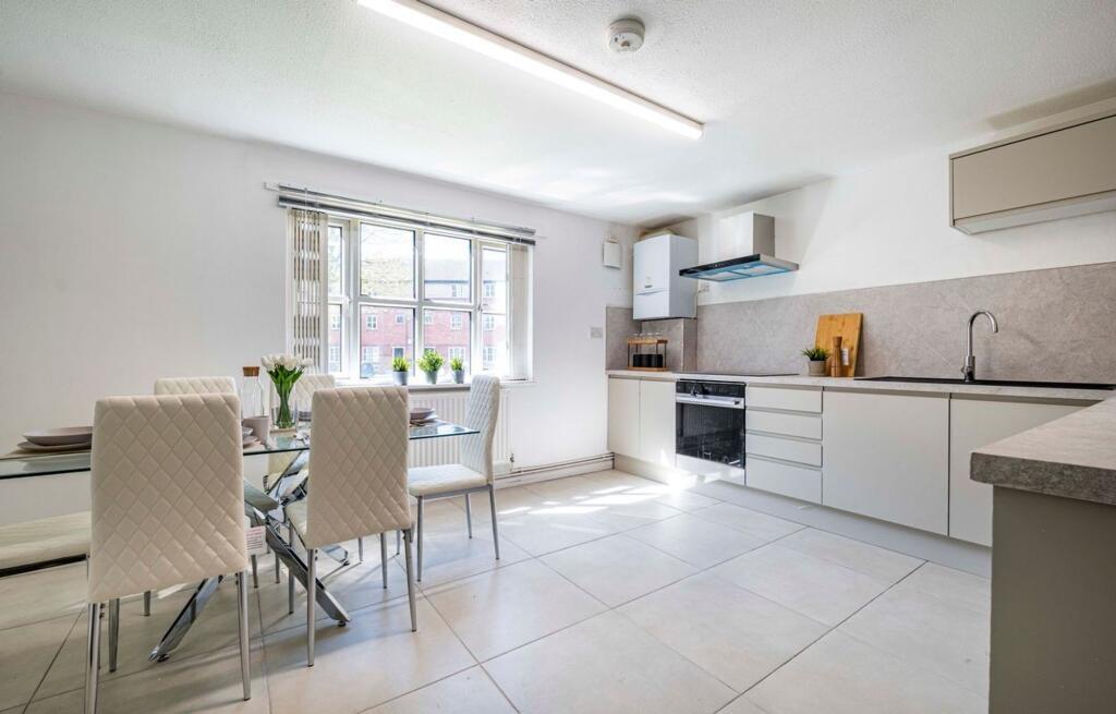 Bright and modern kitchen featuring white cabin...