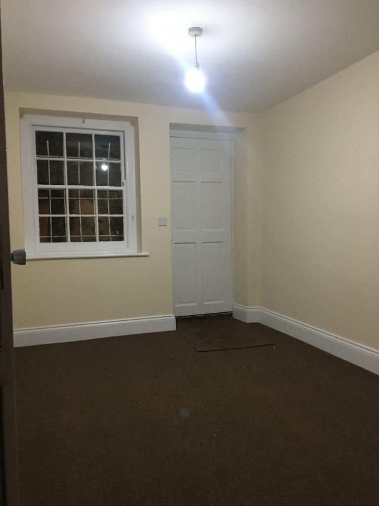 Empty bedroom with neutral walls, a sash-style ...
