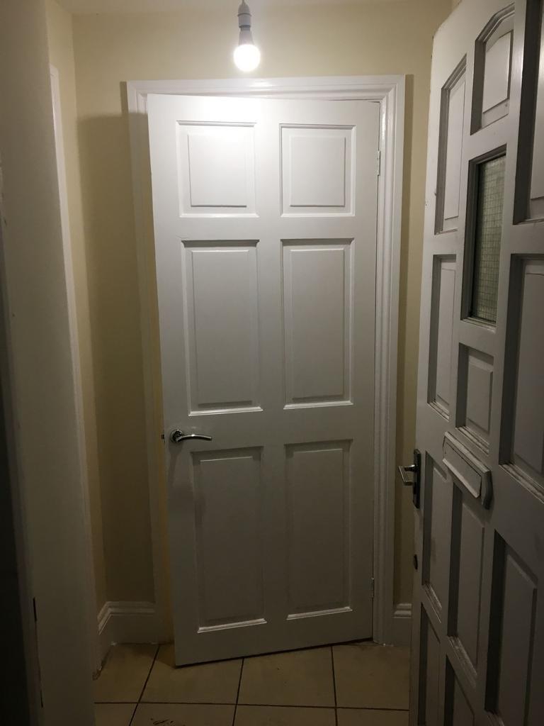 Bright interior hallway with classic paneled do...