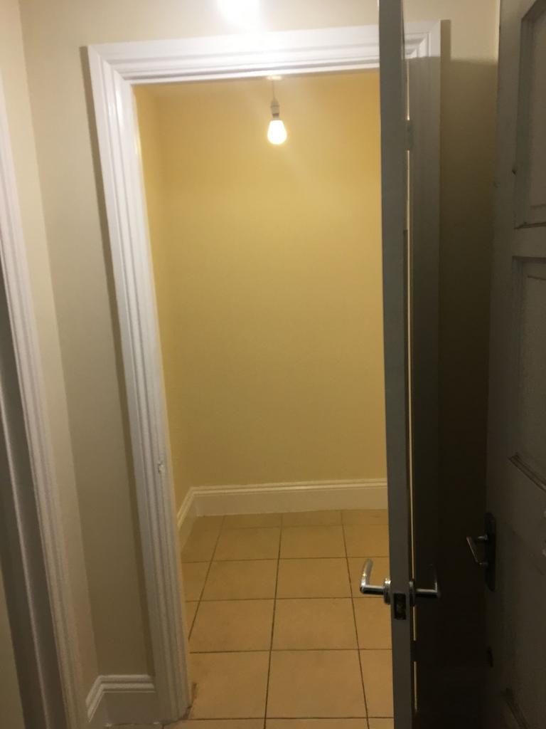 Small tiled storage/closet space with neutral w...