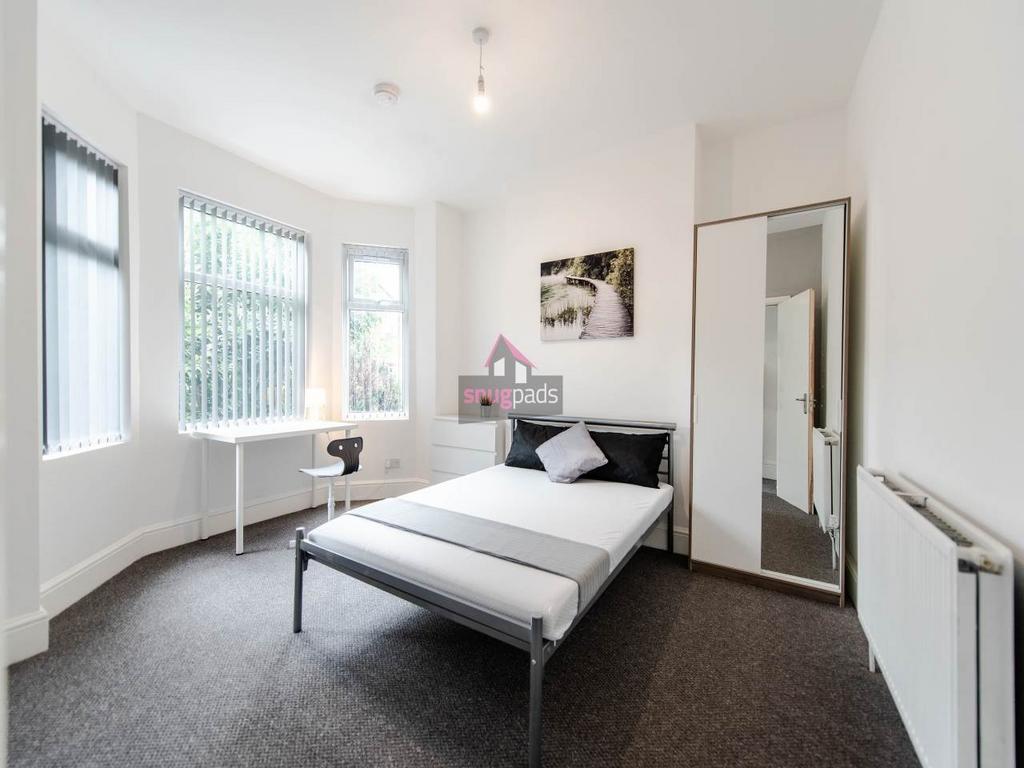 Bright, neutral double bedroom with a metal bed...