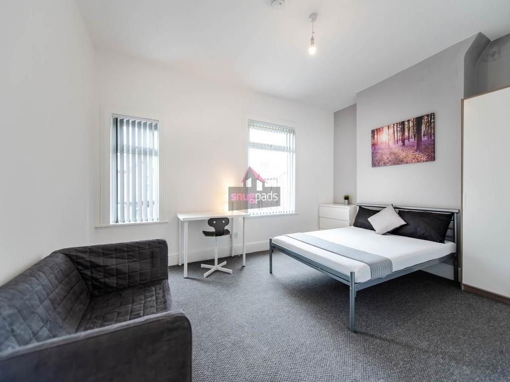Bright, modern double bedroom with a neatly mad...
